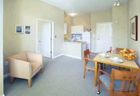 a dining room and kitchen with a table and chairs at Cahill House Senior Apartments in St. Louis, MO