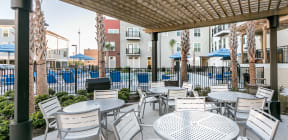 a patio with tables and chairs outside of an apartment building