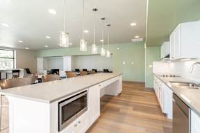 A modern kitchen with white cabinets and stainless steel appliances.