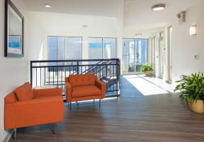 a living room with two orange chairs and a balcony