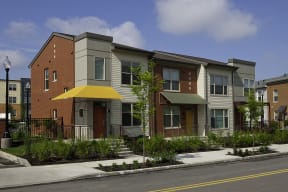 an apartment building with a yellow umbrella on the sidewalk