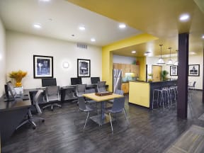 a conference room with desks and chairs and a kitchen with a yellow counter