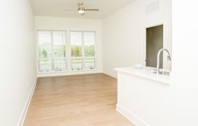 A room with a window, a fan, and a sink.