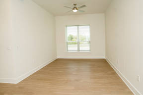 Empty room with a ceiling fan and a window.