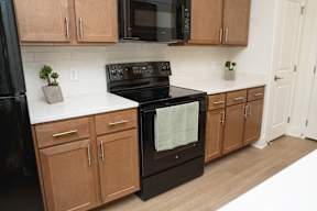 A black oven with a white towel hanging in it.