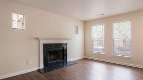 a living room with a fireplace and wooden floors at Crawford Square Apartments & Townhomes