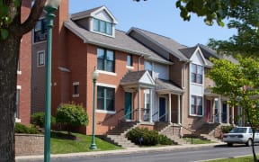 a row of brick apartment buildings on a city street at Crawford Square Apartments & Townhomes