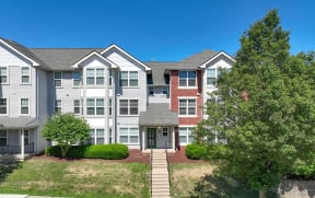 the view of an apartment building with a lawn and trees at Crawford Square Apartments & Townhomes