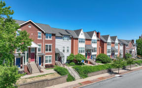 a row of brick and white townhouses on the side of a street at Crawford Square Apartments & Townhomes