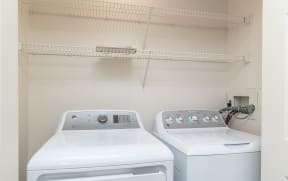 a laundry room with two washes and a dryer at Crawford Square Apartments & Townhomes