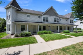 a townhouse with a sidewalk in front of it at Duneland Village apartments and Townhomes in Gary, IN