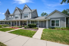 a gray townhouse with a sidewalk in front of it at Duneland Village apartments and Townhomes in Gary, IN