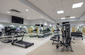 a gym with treadmills and other exercise equipment in a large room