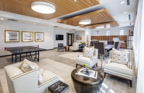 a clubhouse with a ping pong table and a community room at East Meadows Apartments