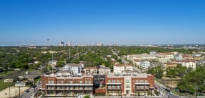 an aerial view of the city with buildings and trees at East Meadows Apartments