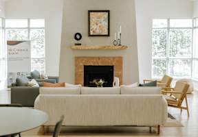 A living room with a fireplace and a painting on the wall.