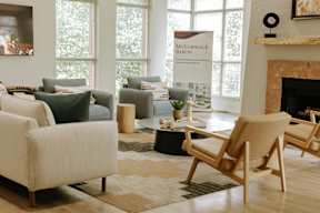 A living room with a fireplace and a banner that says "McCormack Baron".