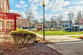 A street view with a red pole and a building in the background.