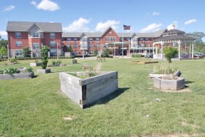 a lawn with plants in front of an apartment building at McCormack House at Forest Park Southeast Senior apartments in St.  Louis, MO