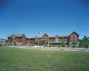 a large red building with an flag in front of it at McCormack House at Forest Park Southeast Senior apartments in St.  Louis, MO