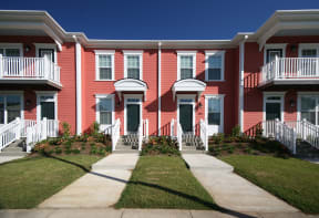 a row of red apartments with stairs and balconies