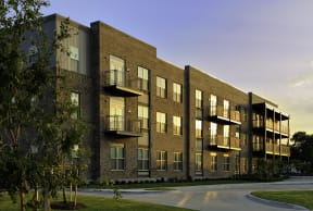 a rendering of a brick apartment building at sunset