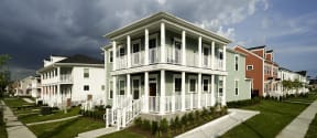 a row of white houses with white railings and a cloudy sky