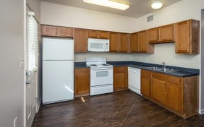 a kitchen with wooden cabinets and a white refrigerator and sink