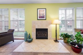 a living room with a fireplace and windows in the community room at Horace Mann apartments and townhomes in Gary, IN