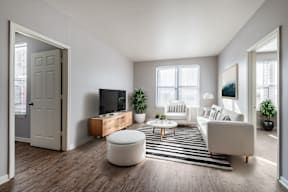 A modern living room with a white sofa, a wooden coffee table, and a flat-screen TV.