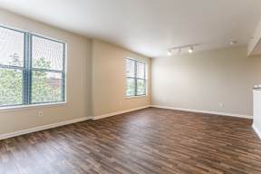 A room with wooden flooring and a window with blinds.