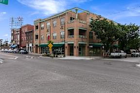 A street view of a building with a green awning and a yellow sign on the front.