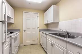 A kitchen with white appliances and cabinets.