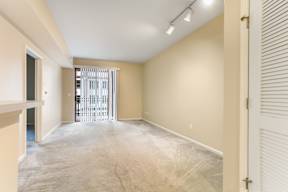 A room with a white door and a window with blinds.