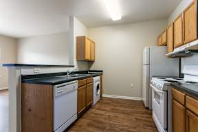 A kitchen with wooden cabinets and black countertops.
