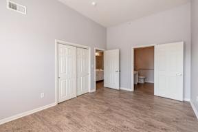 A room with white doors and wooden flooring.