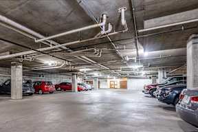 A parking garage with several cars parked.