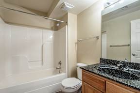 A bathroom with a white tub, toilet, and sink.