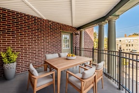 A table with chairs is on a balcony.