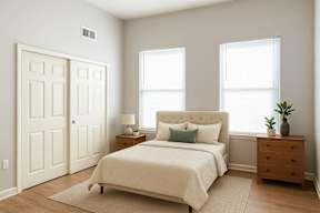 A bedroom with a bed, nightstand, and a door.