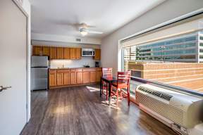 A kitchen with wooden floors and a table with chairs.
