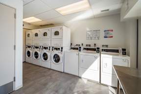 A laundry room with washing machines and dryers.