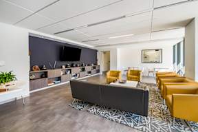 A modern waiting room with a long couch and chairs.