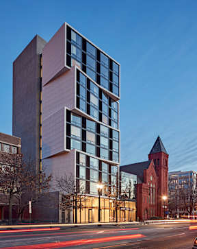A modern building with a clock tower in the background.