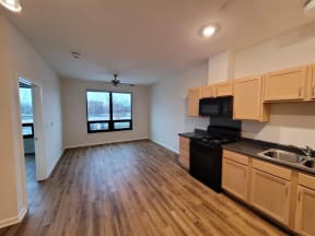 an empty living room and kitchen with wood flooring