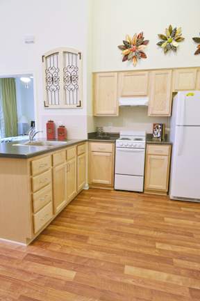 A kitchen with wooden floors and white appliances.