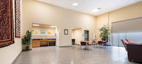 MacArthur Park Apartments clubhouse with a table and chairs and a kitchenette in the background