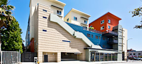 MacArthur Park Apartments; a building with a staircase that is painted blue and orange