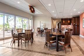A dining room with a table surrounded by chairs.