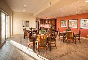 A dining room with wooden floors and chairs.